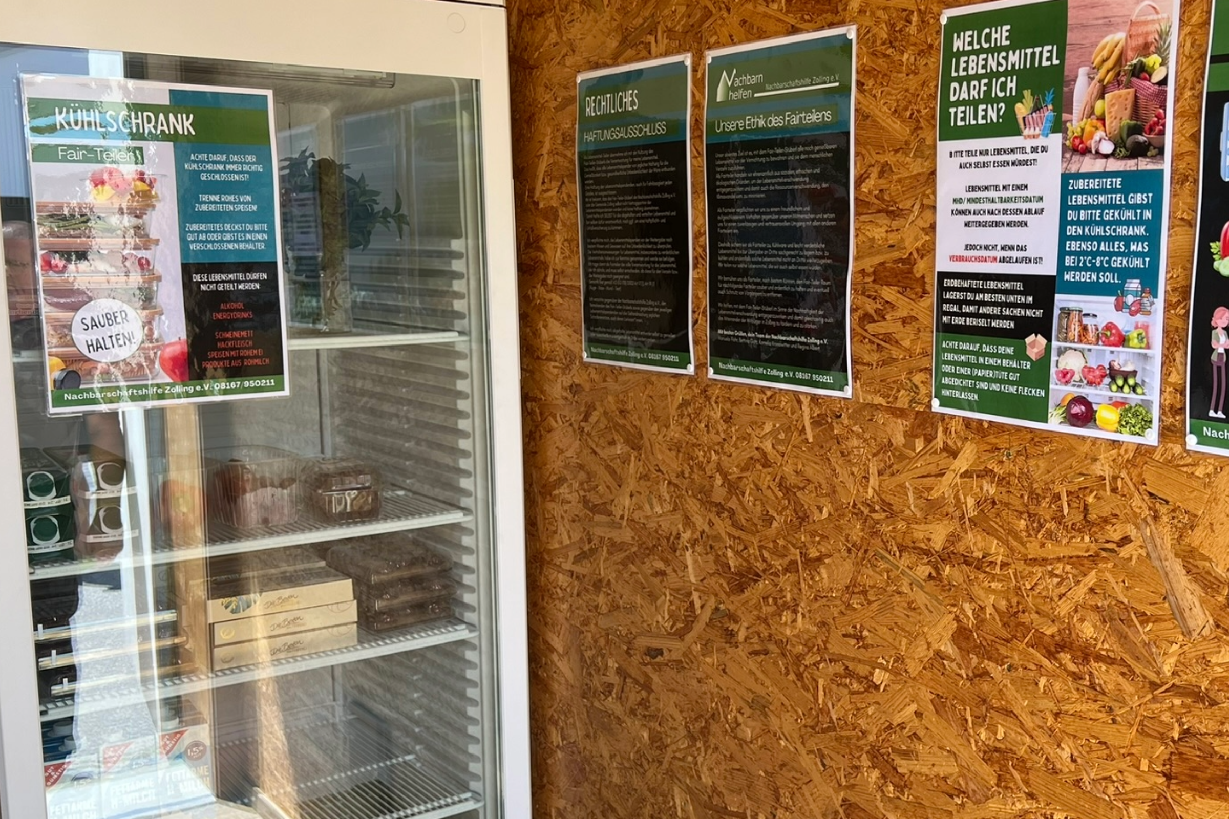 Innenraum des Stüberl mit Kühlschrank und Plakaten an der Wand.