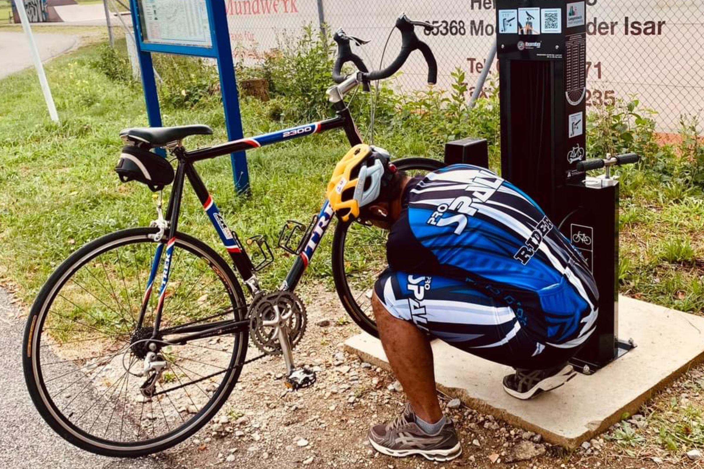 Radlstation wird in Betrieb genommen. Fahrradfahrer nutzt Werkzeug der Radlstation an seinem Fahrrad.