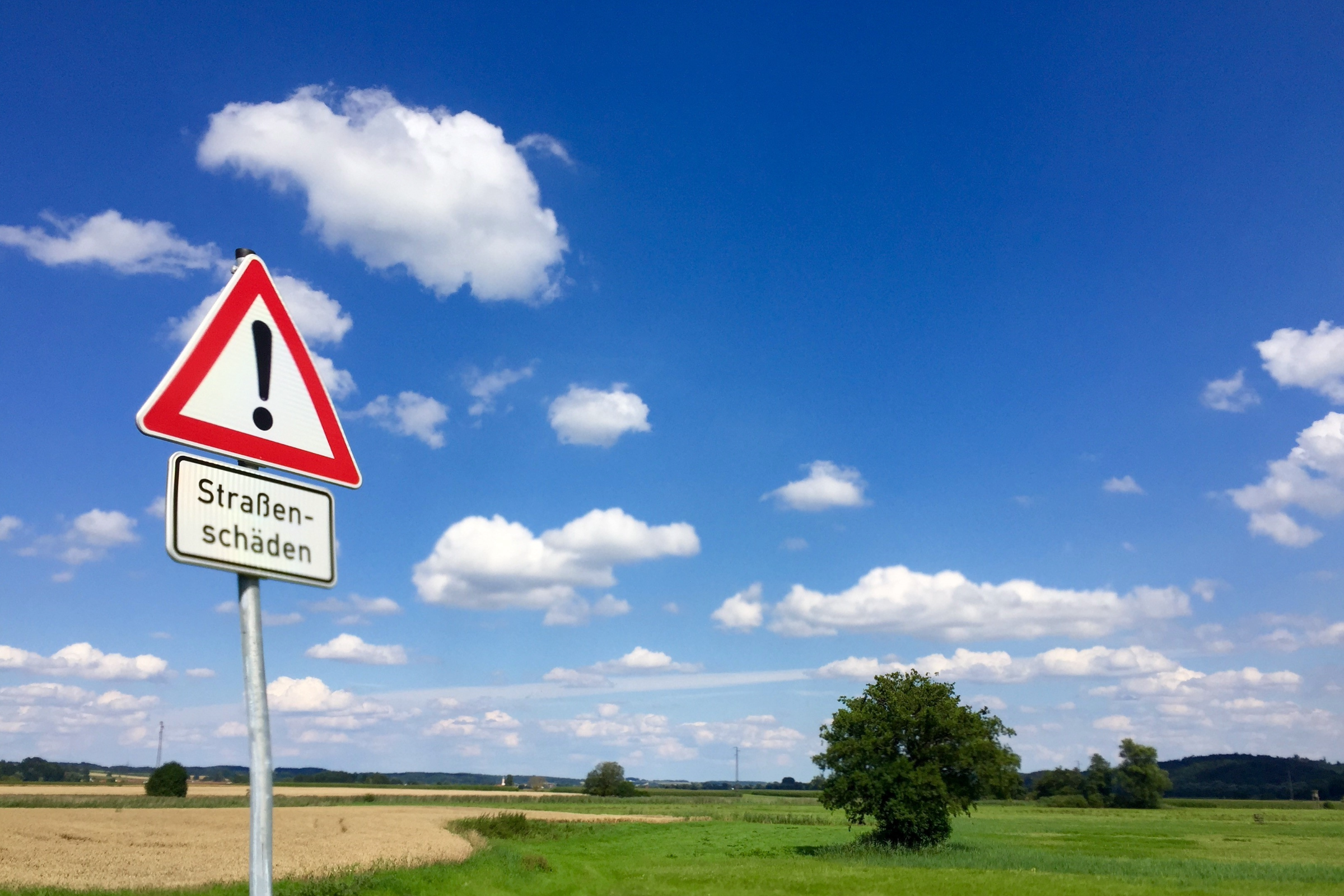 Landschaft und Straße mit Verkehrsschild als Sinnbild der ländlichen Mobilität